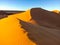 the big dune of Taghit in the Algerian sahara with some tourists at its summit