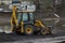 Big excavator during earthmoving works outdoors at construction site. Yellow excavator clears the river bed for the device pond. A