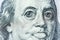 Big eyes of Benjamin Franklin with a hundred dollar bill, a symbol of inflation, appreciation, devaluation, close-up