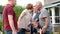 Big family meeting - grown kids visit senior grandparents, three generations meet outdoors