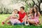 Big family with three little daughters spending time together in summer park