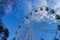 Big Ferris wheel against blue sky with clouds