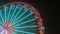 A big festive colorful ferris wheel at night against the background of the night sky. Ferris wheel at night of colorful