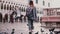 Big flock of pigeons following happy female tourist on amazing San Marco city square in Venice Italy slow motion.