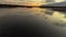 Big flock of swans flying over the amazing lakes landscape at sunset