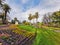 The big flower clock in Kings Park, Melbourne, the surrounding flowerbed lawn and palm trees