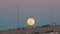 Big Full Moon above the Roof of a Multistory Building is moving up