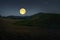 Big full moon over the valley and hills