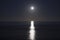 Big full moon is rising above the sea at night. Lunar light reflected on the water. Lunar path. Ocean.