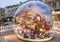 Big glass ball containing with the father Christmas in a street decorated for Christmas