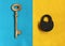 Big golden key on blue felt and close padlock on yellow felt