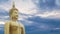 Big great powerful Buddha statue in gold color with beautiful time lapse of sky with cloudy at sunset or sunrise time