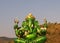 The big green Ganesh statue in the midst of nature In Ratchaburi