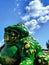 Big green money frog that brings wealth, close-up against the blue sky