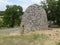 Big grey shelter made of rock on one side of road