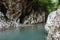 Big grey stone canyon of blue mountain river in greenforest