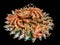 Big hairy boiled crab sits on a heap of dried salted fish on a gift bouquet on the black background