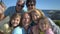 A big happy family takes a selfie or Uses Phone Video Call Camera on the seacoast.