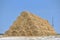 Big haystack from round bales laid in the form of a pyramid against the blue sky