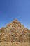 Big haystack from round bales laid in the form of a pyramid against the blue sky