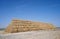 Big haystack from round bales laid in the form of a pyramid against the blue sky