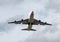 Big heavy jumbo jet cargo airplane flying overhead with blue sky filled with clouds