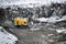 Big huge yellow excavator in granite quarry winter