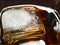 Big Ice Cube in a Glass of Whiskey and Coke Drink. Ice Texture Details