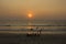 Big indian family on the beach at sunset time. women in colorful sarees