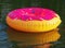 Big inflatable donut on water in sunrise time. Hipster sprinkled donut float in lake