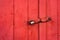 Big iron lock hanging on a red painted door