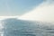 Big isolated foggy cloud on the sea. Foggy weather with detail of a sunlight reflecting in glittering sea. A rare event in the nat