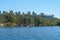 Big lake with blue water, trees and native wetland plants and villa on the cliff