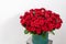 Big luxury bright bouquet on wooden table. One hundred of garden red roses. Color passionately scarlet, Autumn mood