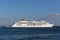 Big luxury cruise ship sailing on calm sea, against blue sky. Day side view of white cruising ship on Tagus river in Lisbon,