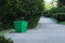 Big metal green painted garbage container in park