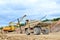 Big mining truck amid huge excavators in an open-pit  dolomite quarry. Loading and transportation of stone ore in a limestone