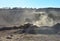 Big mining truck transportion sand in the open-pit. Heavy machinery in the mining quarry, excavators, dozers and trucks. Digging