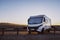 Big motorhome camper parked off road with desert and blue sky in background. Travel lifestyle camping car and freedom. Van against