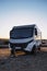 Big motorhome camper parked off road with desert and blue sky in background. Travel lifestyle camping car and freedom. Van against