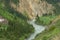 A big mountain river flows along a rocky canyon