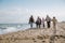 big multigenerational family walking together on beach