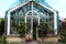 A big old glass greenhouse with plants inside and out