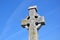 Big old stone celtic cross and blue sky