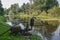 A big old water pump stands on the bank of the river and pumps water.