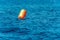 Big orange inflatable signal buoy in the sea