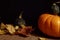 Big orange pumpkin and small green gourds on a black background