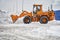 Big orange tractor removing snow