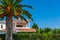 Big palm tree and villa against clear blue sky.