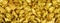 |Big panorama photo of many golden nuggets close-up. Wide background of shiny golden bars. Golden ingot close-up on wide